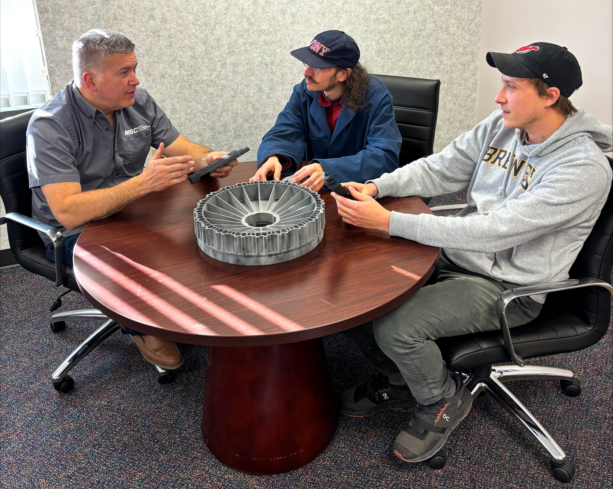 Team members of the 3D Parts Unlimited team meeting at a conference table